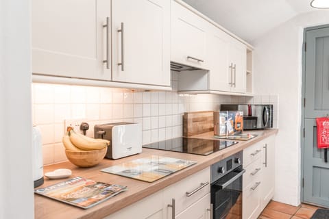 Salty's Cottage, St Agnes. Ground floor: Kitchen with a four-ring induction hob, electric oven, microwave, fridge and dishwasher