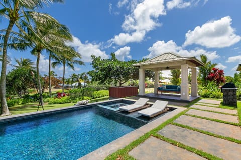 Lush landscaping adds privacy to the pool area with covered cabana and baja shelf lounge chairs
