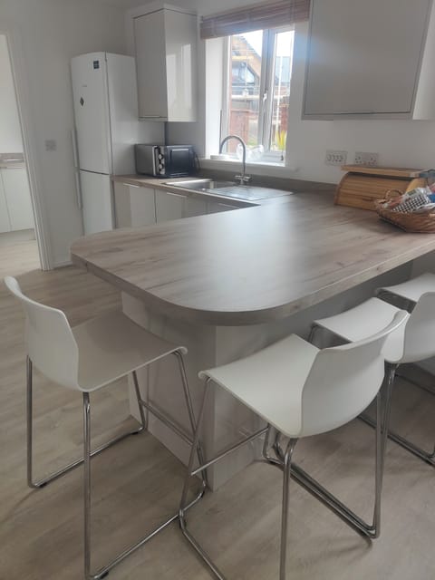 full kitchen with breakfast bar next to dining table