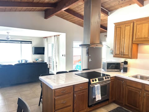 Kitchen Looks into Living Room and Patio Area. Bar Seating at Kitchen Counter.