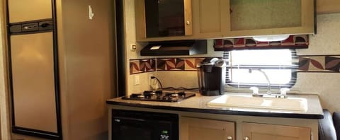 The kitchen has sink, stovetop, microwave, toaster, and Keurig coffee maker