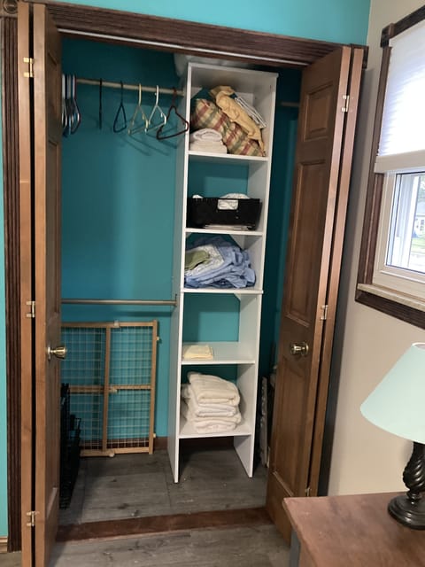 Bedroom 2 - closet with assortment of sheets, towels, room divider for dog