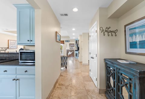 Step into Captain Jax through a bright, inviting entryway featuring coastal décor, natural light, and warm tones that set the stage for your beachside retreat.