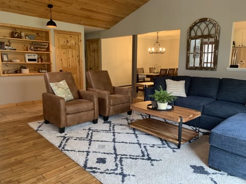 Spacious living room with vaulted ceilings, cozy furniture, fireplace, and view