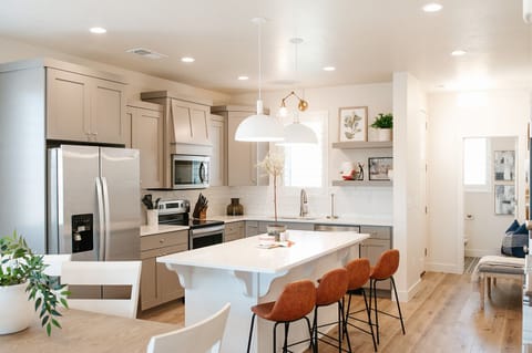 Cook and connect in the modern kitchen with stainless steel appliances, large island seating, and open layout — ideal for family stays near St. George.