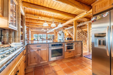 Kitchen with ample granite countertops, a farmhouse sink, and stainless steel appliances