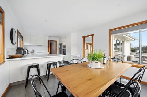 Large dining table with extra chairs, as well as a breakfast bar.