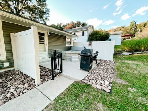 Outdoor patio space with hot tub and grill.