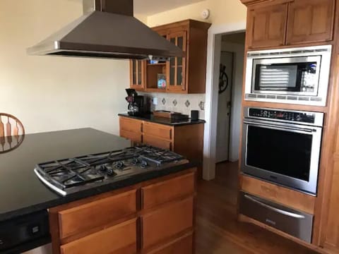 Spacious kitchen with 5-burner gas stove, oven, and microwave