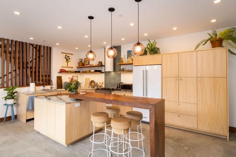 Fridge, oven, sink, drawers, oepn space, table, chairs