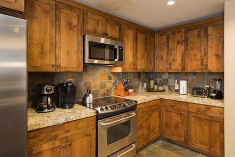 Kitchen and bar area. Fully stocked with cookware and dishware. Traditional drip coffee maker.