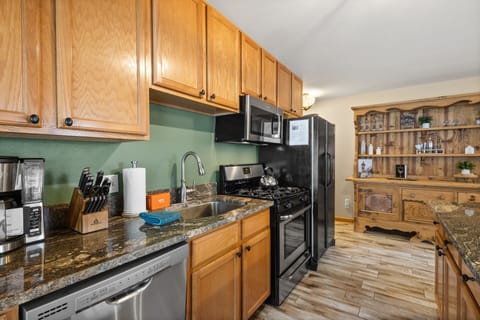 Kitchen side view - Spacious open floor plan kitchen with island bar, gas range, basin sink, microwave and drip coffee maker.