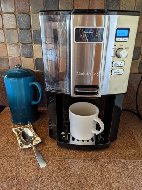 Coffee maker and french press with frother in cabinet above.