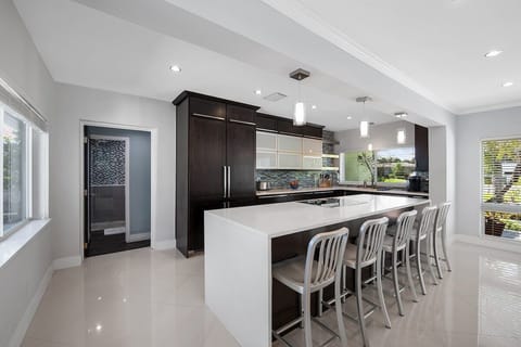 Prepare a family meal in the fully-equipped kitchen offering bar seating, updated appliances and pool views.
