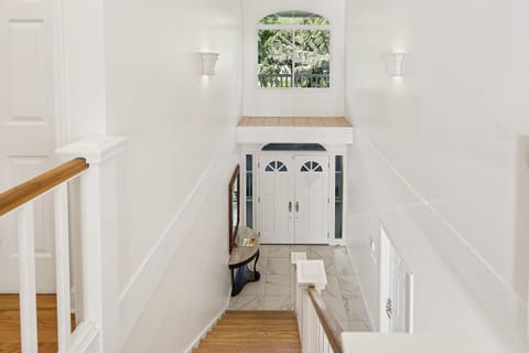 Welcoming grand entryway with elegant staircase — your first glimpse of Dolphin Manor’s charm.