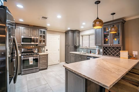 Kitchen features a barstool seating and modern appliances.