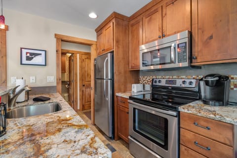Remodeled galley kitchen w/stainless steel appliances and granite counter tops