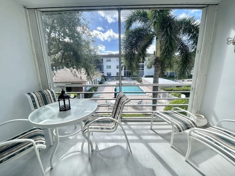Screened balcony overlooking the pool has dining table and chairs for relaxing. 