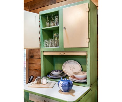 Featuring a pop of color with a bright red countertop and a charming green cabinet, this kitchen is the perfect blend of style and functionality. Ideal for creating memories with loved ones.