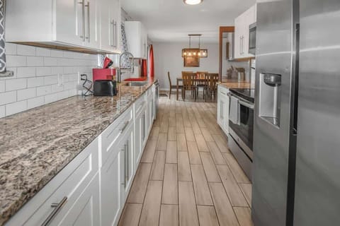 Sleek and modern kitchen featuring elegant granite countertops, stylish white cabinetry, and stainless steel appliances—perfect for cooking and entertaining