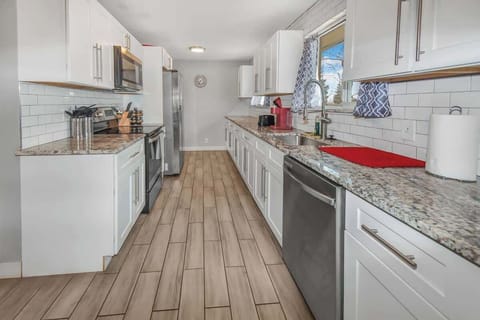 Sleek and modern kitchen featuring elegant granite countertops, stylish white cabinetry, and stainless steel appliances—perfect for cooking and entertaining
