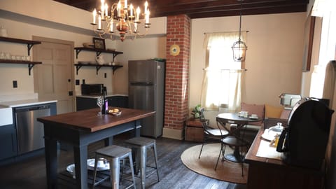 Fully stocked kitchen with original hardwood floors and exposed beams.