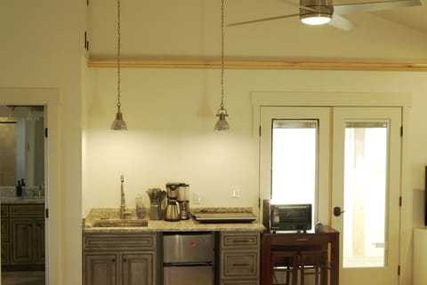 2 burner range; convection oven; mini-fridge; deep-well sink; ceiling fan.