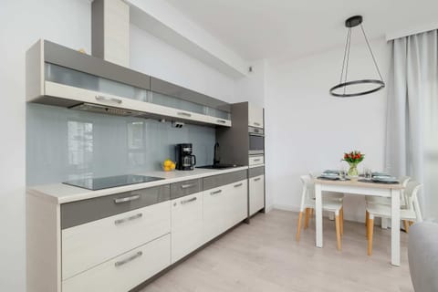 Modern kitchen with bright cabinets, wood accents and built-in appliances, combining functionality with clean design.