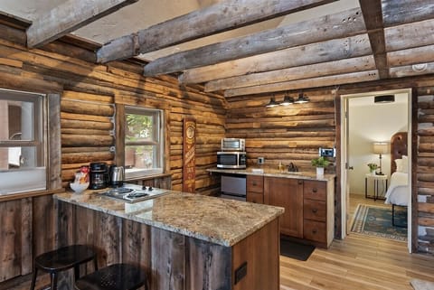 The kitchenette in our historic cabin is perfect for light cooking with a 2-burner stove, mini fridge and freezer, microwave, sink, and toaster.