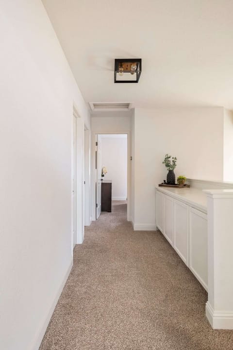 Upstairs hallway looking from the primary room towards two bedrooms and bathroom