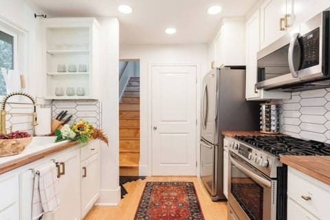 Full kitchen with stainless steel gas stovetop, microwave, and oven set