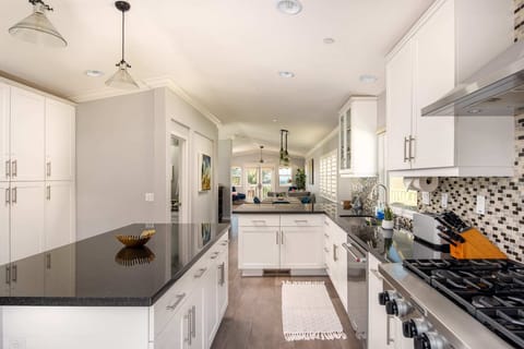 The open floor-plan seamlessly connects the kitchen, dining, and living areas on the top level.