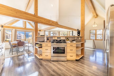 High end full-size kitchen with granite countertops, modern stainless steel appliances and vaulted ceiling.