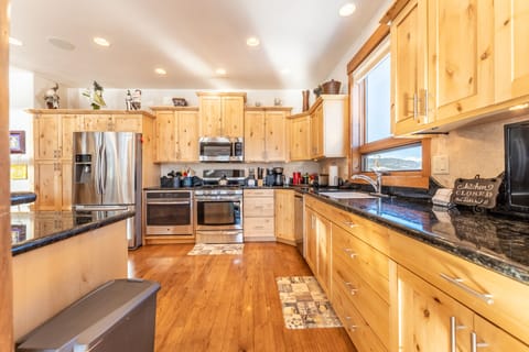 Spacious updated kitchen with modern stainless steel appliances, granite countertops and small flat screen TV.