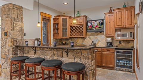 Wet bar with bar seating and TV