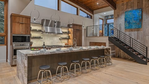 Gourmet kitchen with 6-burner gas range, 3 dishwashers, and bar seating for 7