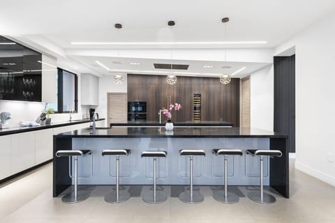 Modern gourmet kitchen featuring long breakfast bar and top-tier appliances