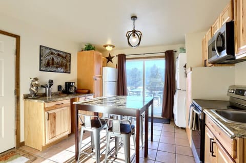- Cook in a charming rustic kitchen with granite counters and wood cabinetry
- Enjoy cozy meals at the high top table with seating for four under antler lighting
- Step through the sliding doors to soak in peaceful pine and mountain scenery