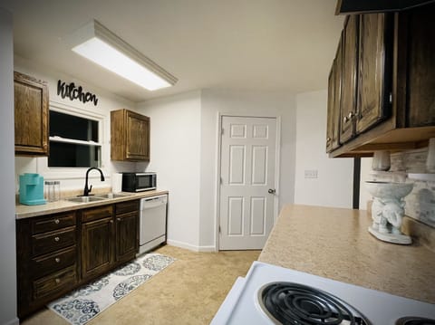 Kitchen provides access to the laundry room, patio and backyard