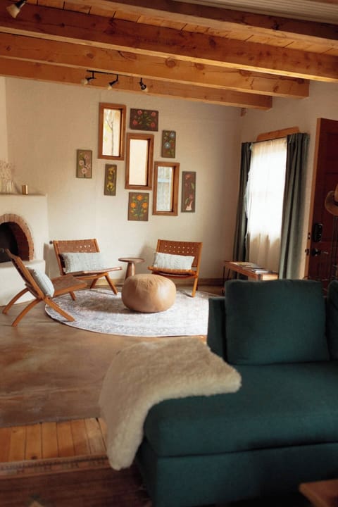 The living room is split into two separate seating areas. One around the fire place, and another around the TV.