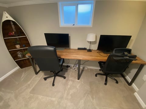 Office has a two-station desk complete with widescreen monitors
