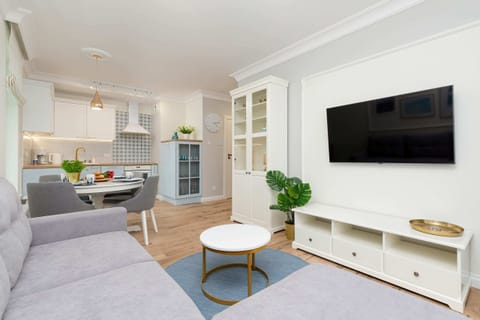 Living room with a gray sofa, wall-mounted TV, and modern decor.
