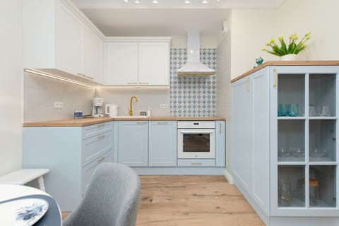 Open kitchen with white cabinets, wooden details, and a functional layout.
