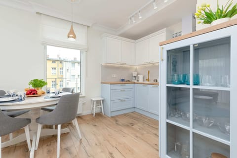 Kitchen with white cabinetry, shelves, and modern appliances.
