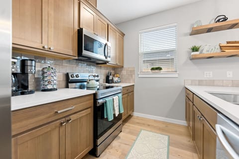 Stainless steel appliances including a full-size fridge/freezer and dishwasher.