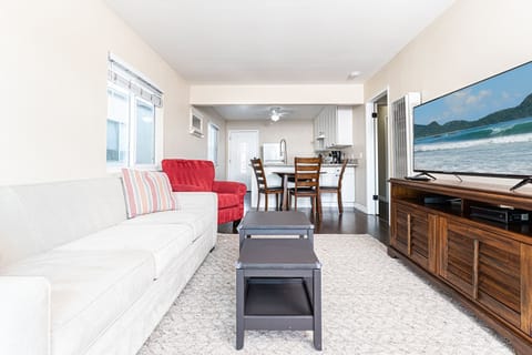 This upstairs apartment includes a small living area for unwinding after a day in the sun, with dining and kitchen area beyond.
