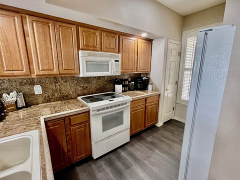 Full kitchen with fridge with freezer, microwave, oven with stovetop, dishwasher