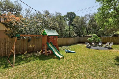 Family-friendly backyard fun shines with a playset, open lawn, and fire pit—perfect for pets, kids, and relaxed North Austin evenings.