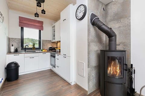 A modern living room with a fireplace, a coffee table, and a cozy sofa, accented by wooden decor.

