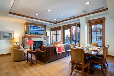 Open living and dining space with fireplace and village views
